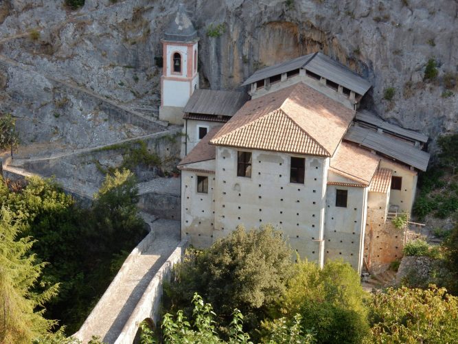 Veduta aerea del Santuario della Madonna del Pollino costruito a ridosso di una imponente parete di roccia