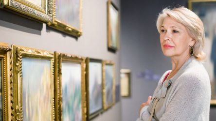 Photo of a woman looking at paintings in a museum