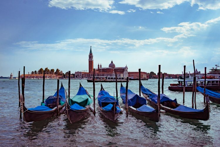 Foto di gondole a Venezia con sfondo della Chiesa di San Giorgio Maggiore.