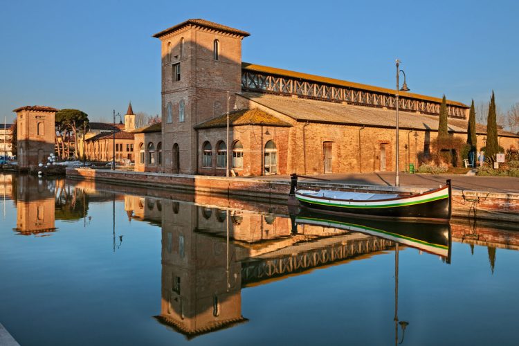 Cervia foto del il canale del porto con lantico magazzino del sale e uno storico peschereccio dellAdriatico.