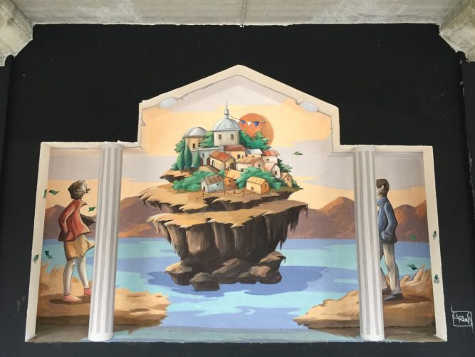 sullo sfondo, al centro del lago, un’isola con delle case.