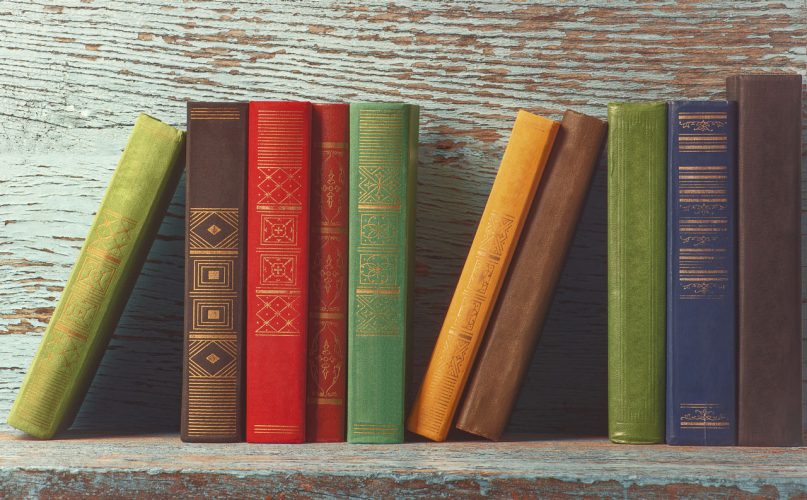 Foto di una collezione di libri antichi su una mensola.