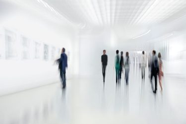 Museum hall with people looking at the works of art.